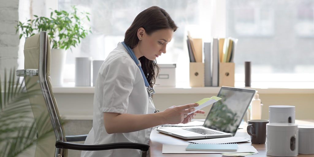 Doctor at her desk looking over paperwork.