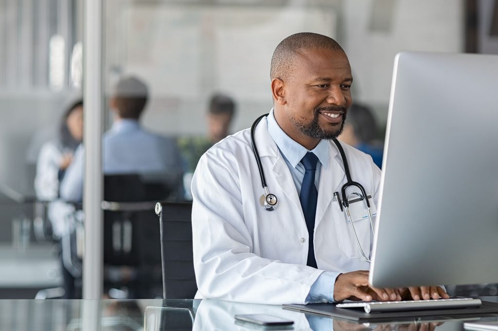 African mature doctor working on computer